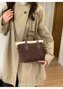 Close-up of brown suede bucket bag with white plush trim and golden metal hardware