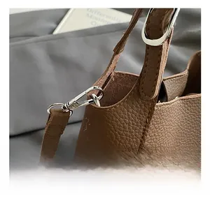 Detailed close-up of premium brown lychee pattern leather strap with silver metal buckle