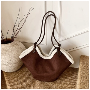 Detail of dark brown suede shoulder bag featuring thick white faux shearling trim accents