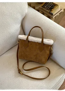 Detailed macro of brown suede bucket bag with faux fur trim and monogram texture