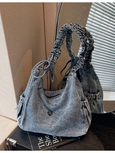 Retro washed blue denim crossbody bag with ruched strap and vintage metallic M logo