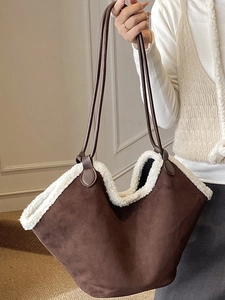 Brown suede tote bag with white faux fur trim and leather handles in a minimalist style