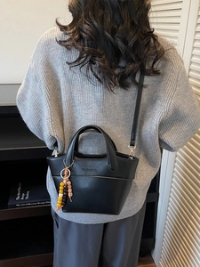 Retro-Eimertasche aus schwarzem Leder mit Griffen und buntem Perlenanhänger-Detail