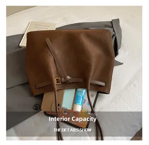 Dettaglio della grande capacità della borsa tote in pelle intrecciata caffè con fibbia in metallo