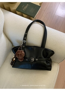 Detail of vintage black oil-wax leather tote with pleats and checkered hat charm decoration
