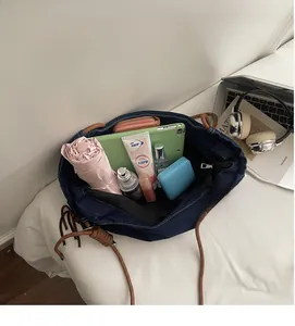 Spacious interior of dark blue denim tote bag showing storage for tablet and essentials