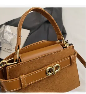 Detail der braunen Lederhandtasche mit Kontrastnähten und metallischem Drehverschluss