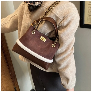 Detail of vintage brown suede bag with white faux fur trim and gold chain strap