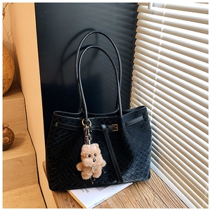 Dettaglio della borsa tote nera intrecciata con un simpatico ciondolo a forma di cane