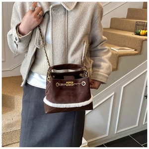 Detail of brown quilted bucket bag with white faux fur trim and gold chain strap