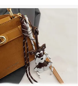 Detailaufnahme der braunen Wildledertasche mit Schnauzer-Anhänger und Flechtseil