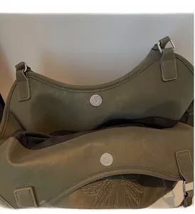 Close-up of olive green leather tote featuring dual silver magnetic snap closures