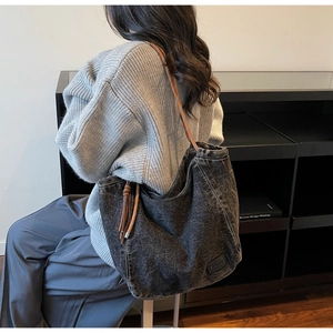 Detail of black washed denim tote bag showing side drawstring and marble texture finish
