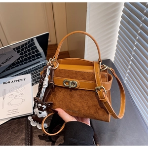 Details der Vintage-Tasche mit Welpen-Anhänger und gemischter Wildleder-Textur