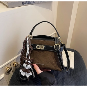 Detailaufnahme aus braunem Wildleder und schwarzem Leder mit Metallschnalle