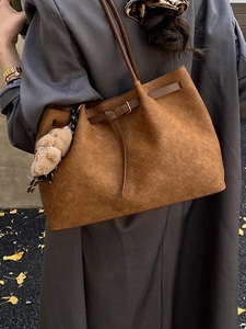 Borsa tote intrecciata marrone con ciondolo a forma di orsetto in un set autunnale
