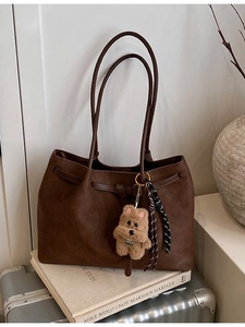 Borsa tote marrone scuro con trama intrecciata, ciondolo a orsetto e manici in pelle