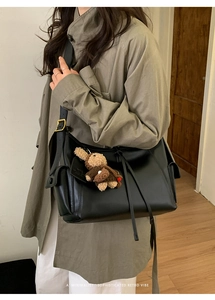 Sac sous le bras en cuir noir minimaliste avec un pendentif ours en peluche marron