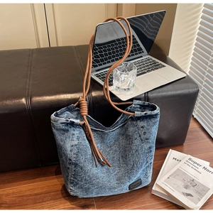 Détails du cabas en jean délavé avec texture robuste et poignées en corde orange
