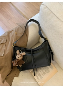 Détail du sac à bandoulière noir avec un petit ours en peluche marron tricoté