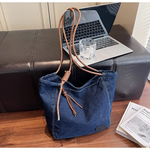 Détail du grand sac cabas en denim bleu avec bandoulière en corde tressée stylée