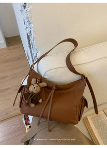 Détail du sac cabas en cuir marron rétro avec sangles et pendentif ours mignon