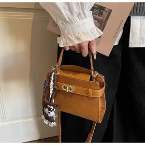 Detail der braunen Retro-Quadrat-Tasche mit Wildleder-Struktur und goldener Metallschließe