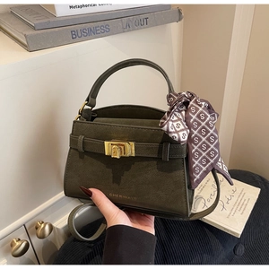 Close-up of olive green crossbody bag with gold lock and decorative silk scarf