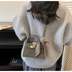 Olive green faux leather handbag with a patterned silk scarf and metal turn-lock buckle