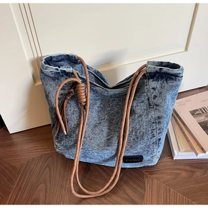 Détail du sac seau en jean avec bandoulière en corde tressée et délavage neige