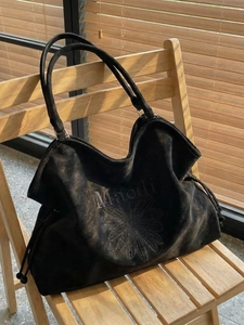 Retro black matte tote bag with daisy print on a wooden chair under natural sunlight