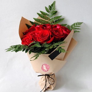 Red rose bouquet in kraft paper wrap with Happy Mother's Day round sealing sticker