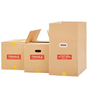 Three kraft cardboard boxes with red fragile stickers and yellow packaging tape on white background