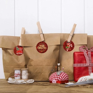 Red Merry Christmas round seal stickers with reindeer and car on a kraft paper gift bag
