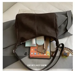 Vista interna della grande borsa tote in pelle scamosciata marrone con tablet e oggetti
