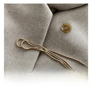 Gros plan sur les détails de la chaîne serpent dorée sur tissu de costume gris
