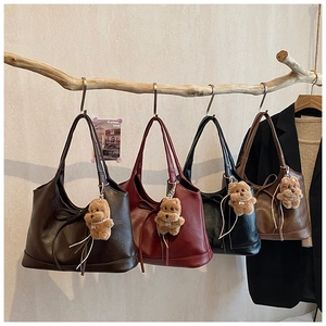 Detailed display of four textured vintage bucket bags with ribbon bows and puppy charms