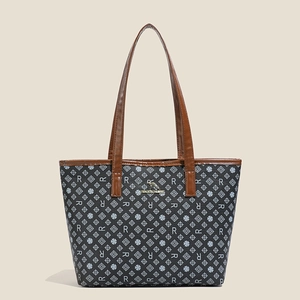 Close-up of repeat R-letter pattern and golden kangaroo logo on a large tote bag