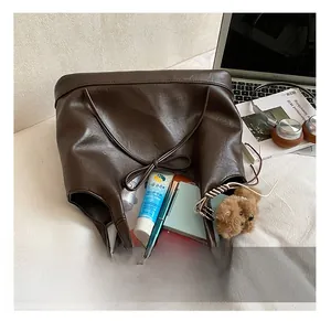 Detailed internal view of large brown tote bag showing spacious capacity and bow closure