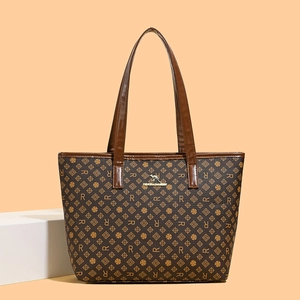 Detail view of large tote bag with brown monogram pattern and golden kangaroo logo