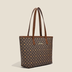 Macro shot of dark brown tote bag showing R-letter pattern and golden kangaroo logo