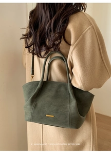 Detail of dark moss green matte tote bag featuring gold hardware and minimalist design