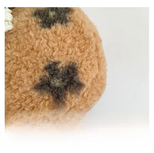 Close-up of brown plush bucket bag fabric featuring a fuzzy floral pattern and drawstring