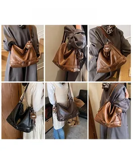 Detail view of large PU leather tote bag with decorative buckle and plush charm