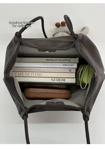 Interior view of large capacity faux leather tote bag showing books and daily essentials