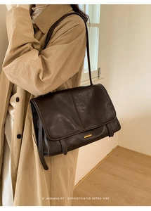 Detailansicht der dunkelbraunen Retro-Ledertasche mit elegantem Gold-Metall-Verschluss
