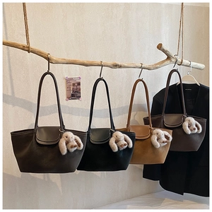 Artistic display of four minimalist tote bags in earth tones with bunny pendants