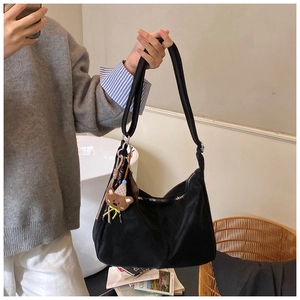 Dettaglio della borsa tote nera in nylon con ciondolo a orsetto e zip in metallo