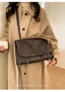 Detailansicht einer dunkelbraunen Vintage-Umhängetasche aus Leder mit goldener Schnalle