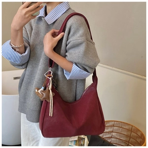 Dettaglio della borsa hobo bordeaux con ciondolo a stella e tracolla in pelle morbida